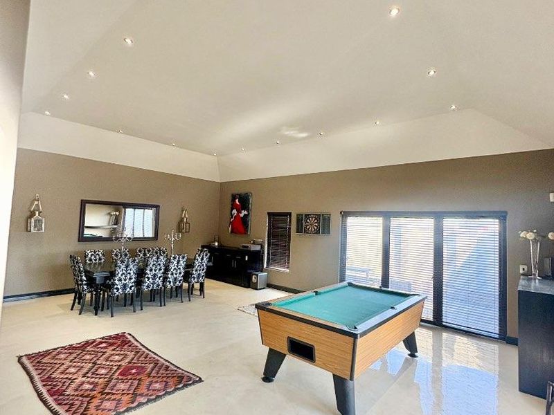 Spacious living area featuring a high vaulted ceiling, recessed downlighting, polished concrete floors, and large sliding glass doors providing ample natural light.