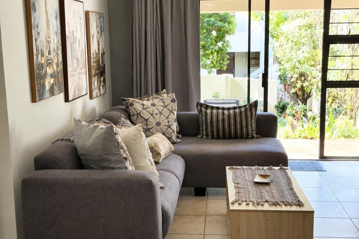 A comfortable living room featuring tiled flooring and a large sliding glass door that provides direct access to the outdoor patio area.