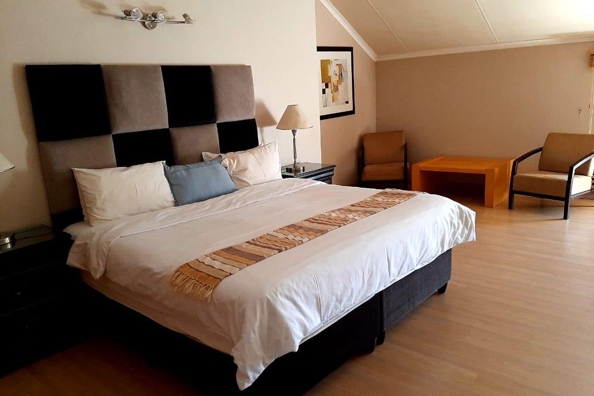 Spacious bedroom featuring laminate flooring and a sloped ceiling, providing a comfortable and well-maintained living space.