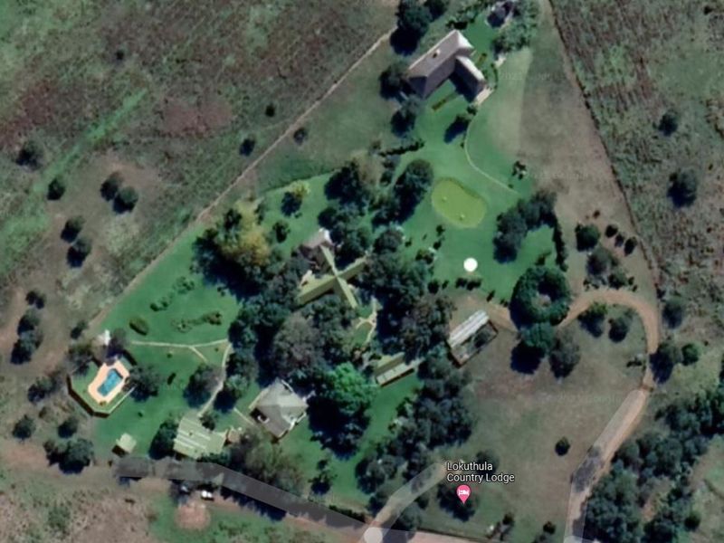 Aerial view of the Lokuthula Country Lodge property, showcasing the layout of multiple buildings, swimming pool, and extensive landscaped grounds.