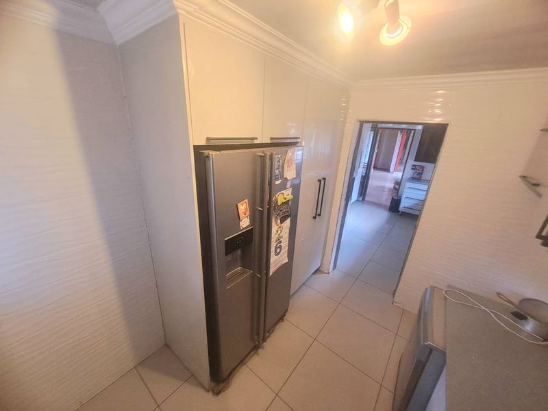 A functional kitchen area featuring built-in cabinetry and tiled flooring, providing a clean and practical workspace.