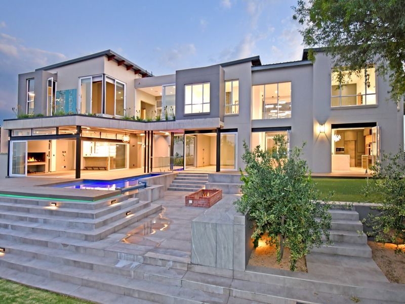 Modern luxury rear elevation featuring a multi-level terrace, integrated swimming pool, sunken fire pit, and expansive glass sliding doors for seamless indoor-outdoor living.
