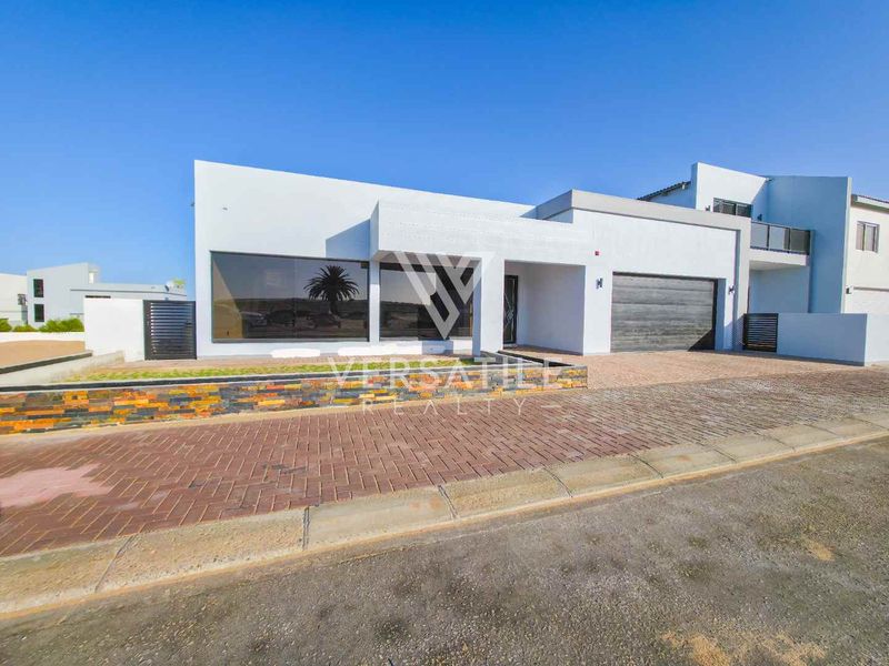 Modern contemporary house exterior featuring clean white lines, stone cladding accents, a paved driveway, and a double garage.