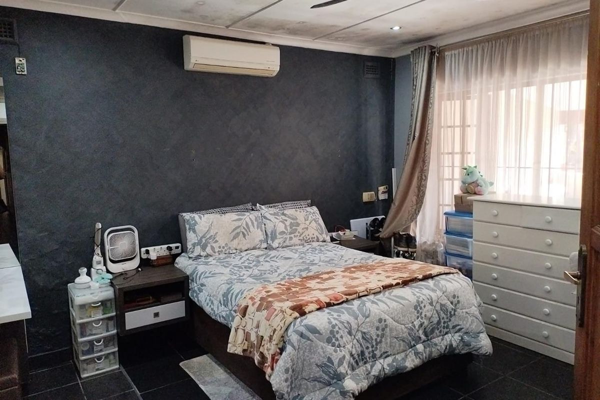 A bedroom featuring dark textured walls, tiled flooring, a ceiling fan, and a wall-mounted air conditioning unit.