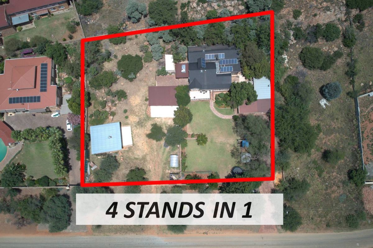 Aerial view of a large residential property featuring multiple structures, solar panel installations, and expansive landscaped grounds.