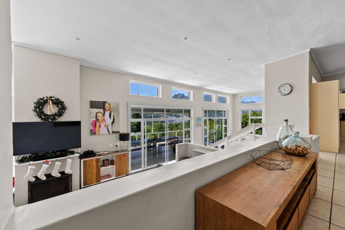 Spacious living room featuring a built-in fireplace, large sliding glass doors, and clerestory windows that provide ample natural light and scenic views.