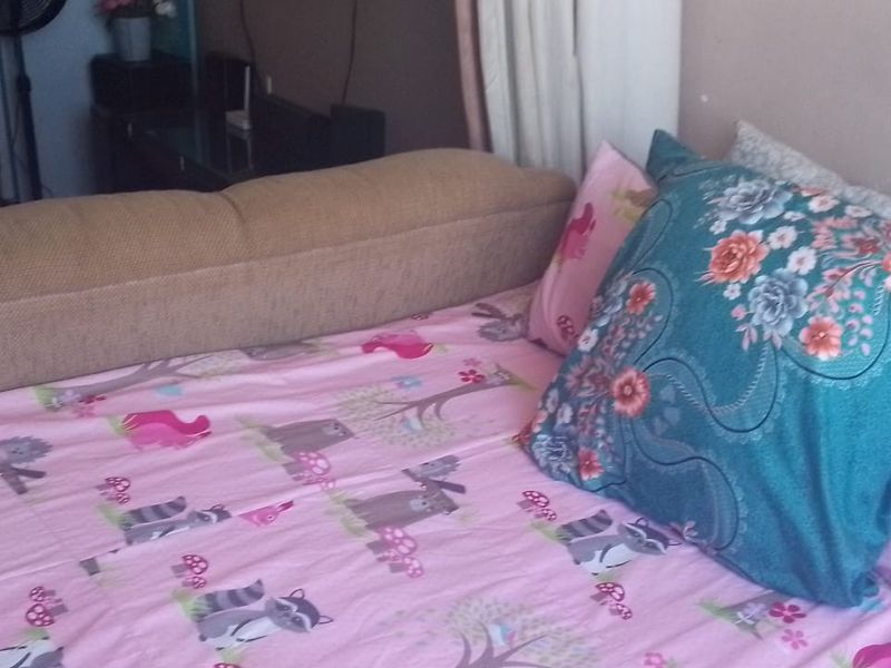 A bedroom interior view showing a bed with patterned bedding.