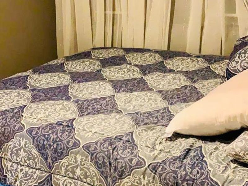 A bedroom featuring tiled flooring and window treatments.