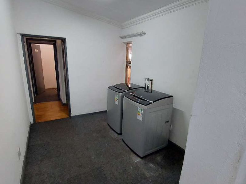 A functional laundry area featuring plumbing connections and basic lighting, providing a practical space for utility tasks.