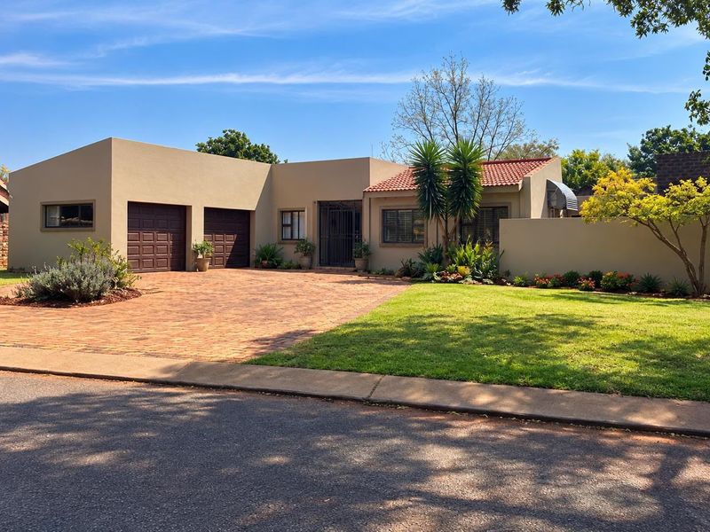 Well-maintained single-story residence featuring a double garage, paved driveway, and established front garden with secure entrance.