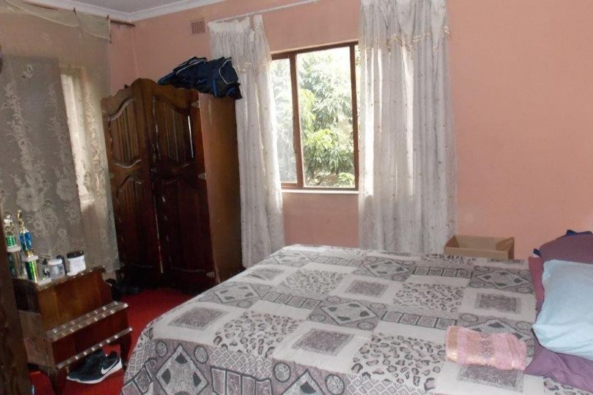 A standard bedroom featuring a window with natural light and decorative cornice detailing.