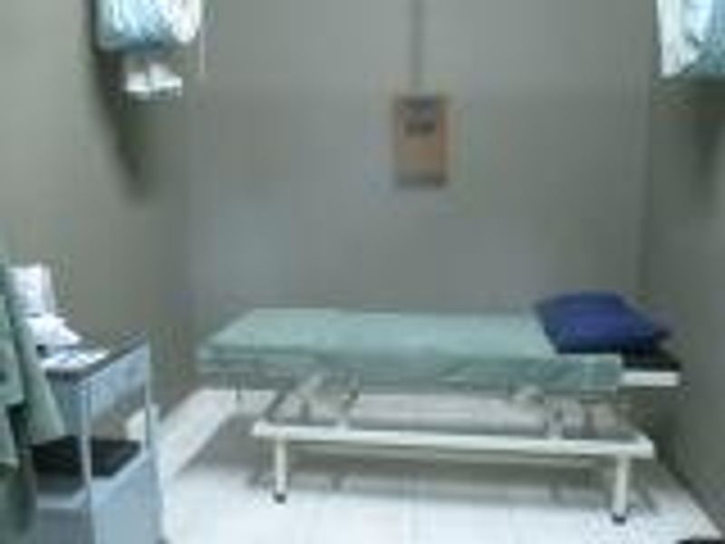 A functional clinical or utility room featuring tiled flooring and basic wall-mounted electrical infrastructure.