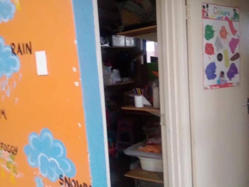 A small utility or storage closet featuring built-in shelving, accessed via a standard interior door.