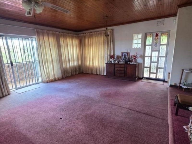 Spacious living area featuring a timber tongue and groove ceiling, ceiling fan, and sliding door access to the exterior.