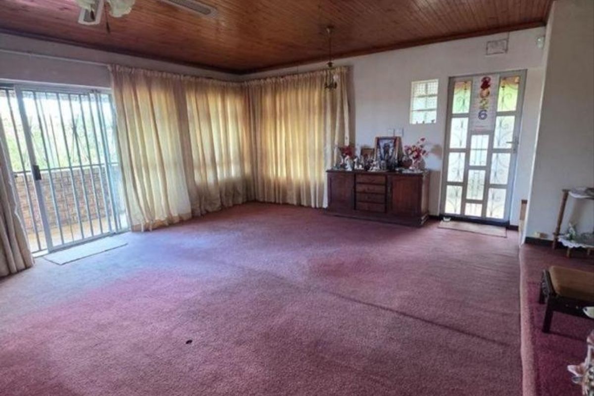 Spacious living area featuring a timber tongue and groove ceiling, ceiling fan, and sliding door access to the exterior.