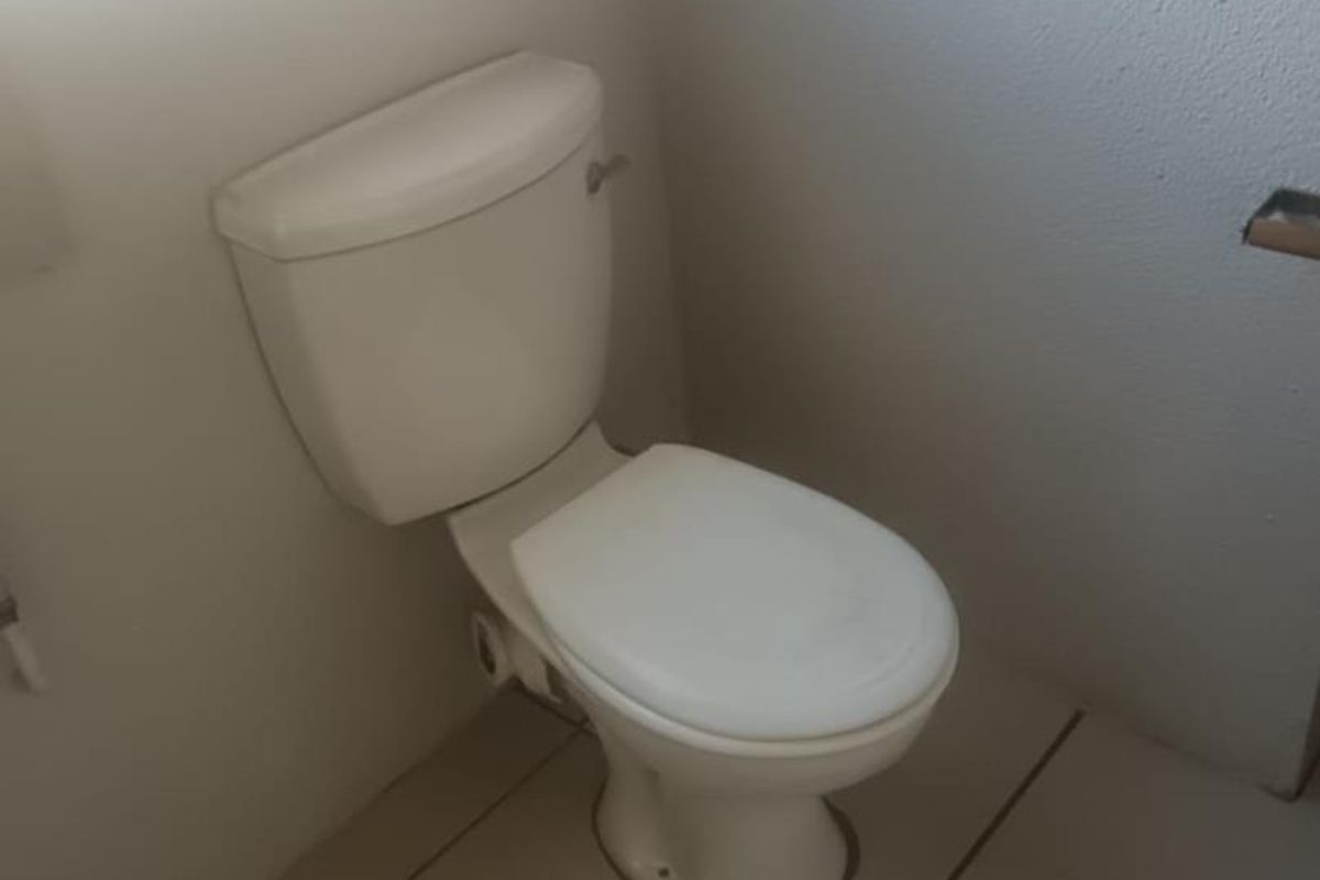 A functional bathroom featuring a standard white toilet and tiled flooring.