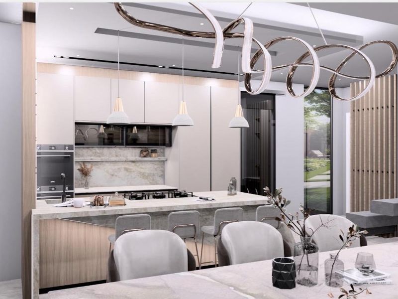 Modern open-plan kitchen and dining area featuring high-end stone finishes, integrated appliances, and sophisticated feature lighting.