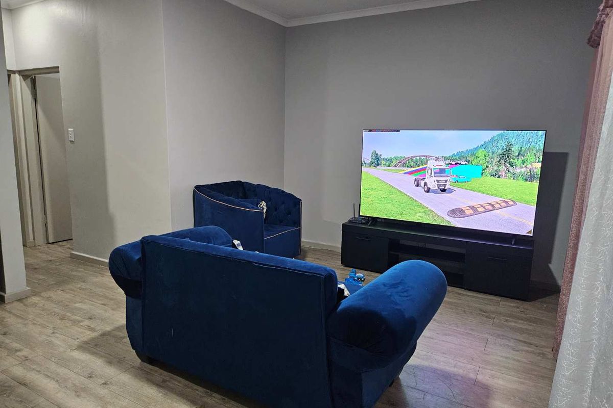 A living room featuring light-toned wood-look flooring and neutral wall finishes, providing a functional and comfortable space for relaxation.