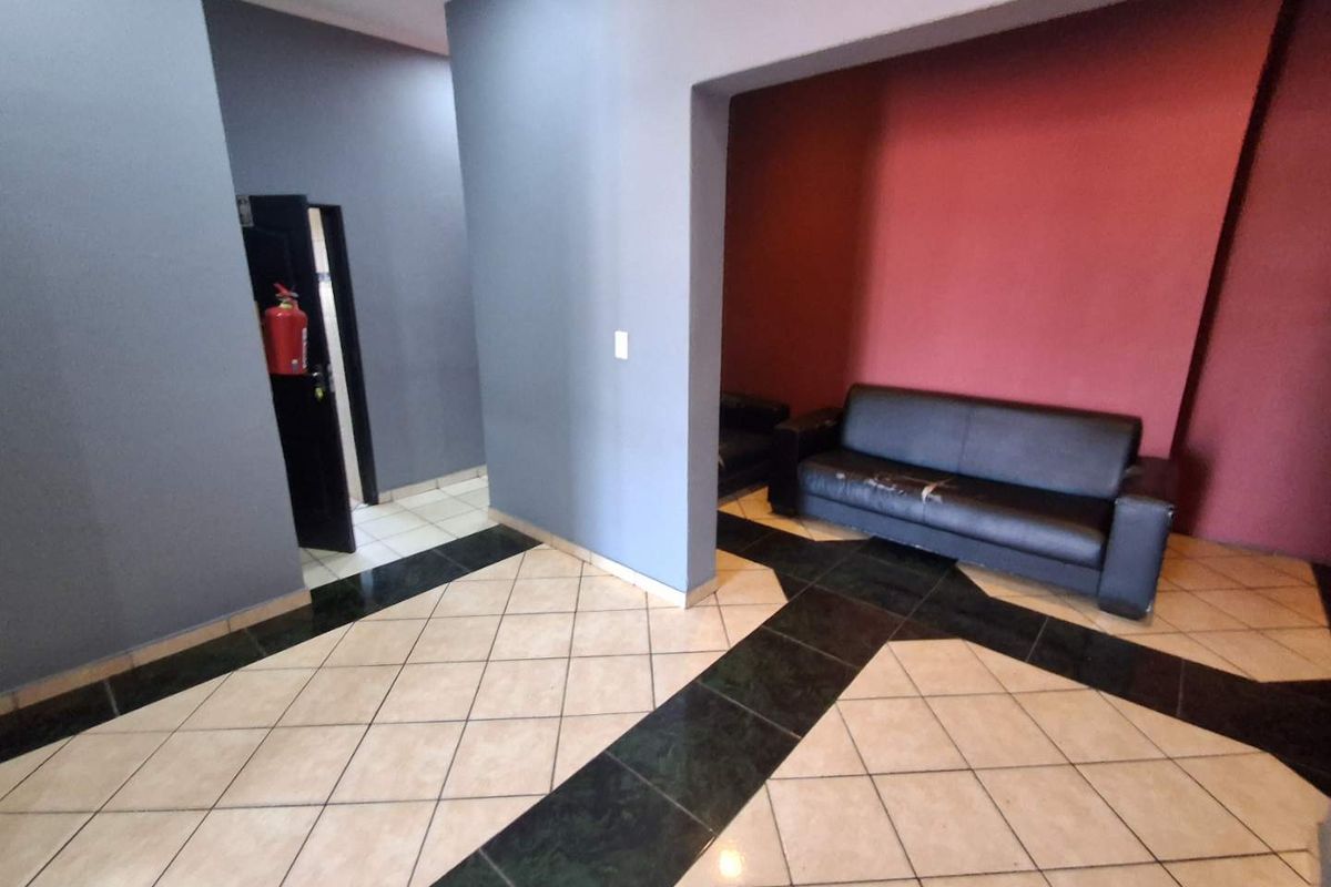 A living area featuring a distinct two-tone wall color scheme and patterned ceramic floor tiling with a recessed seating alcove.