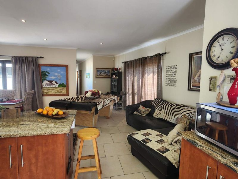 Spacious open-plan living area featuring tiled floors, granite kitchen countertops, and sliding doors providing access to the outdoor space.