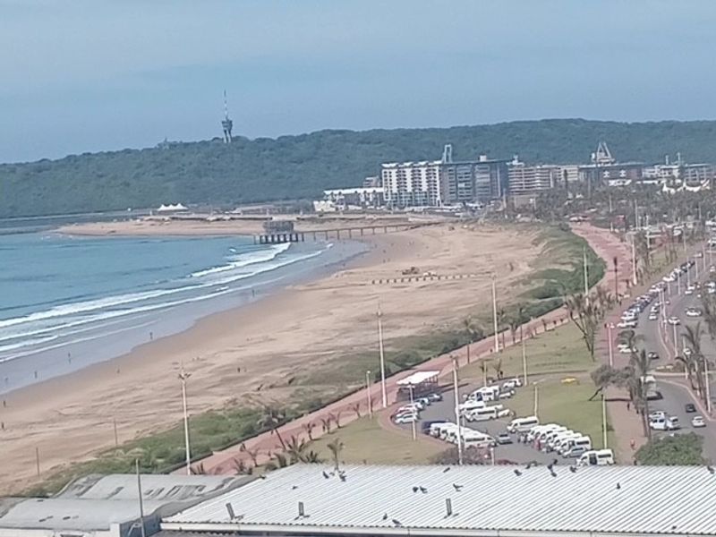 Elevated coastal view overlooking the beach, promenade, and surrounding urban landscape.