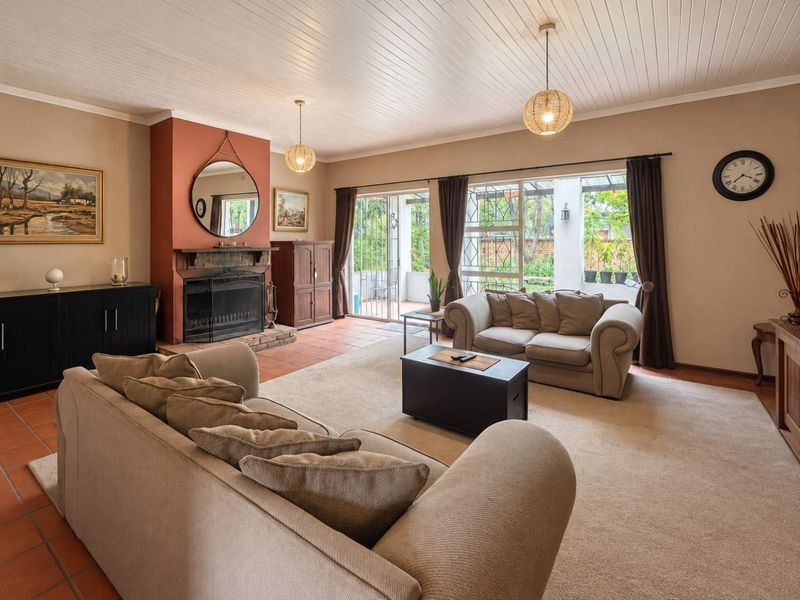 Spacious living room featuring a fireplace, terracotta tiled flooring, and sliding glass doors providing access to the outdoor patio area.