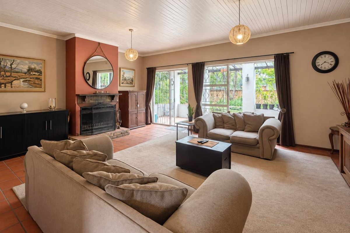 Spacious living room featuring a fireplace, terracotta tiled flooring, and sliding glass doors providing access to the outdoor patio area.