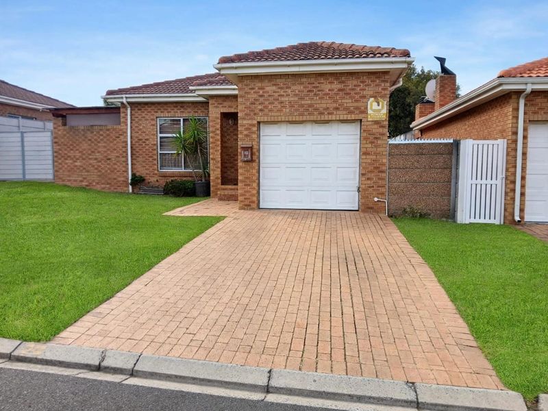 Front view of a single-story brick house featuring a paved driveway, single garage, and well-maintained front lawn.