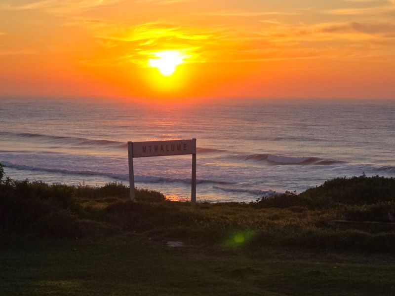 A scenic sunset view overlooking the ocean at Mtwalume, showcasing the natural coastal landscape.