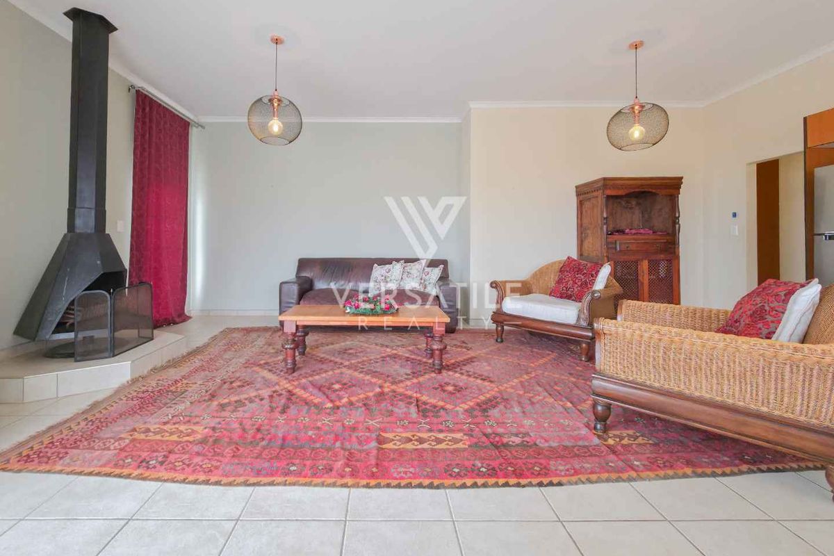 Spacious living room featuring a prominent freestanding fireplace, neutral walls, and tiled flooring, offering a comfortable and inviting atmosphere.