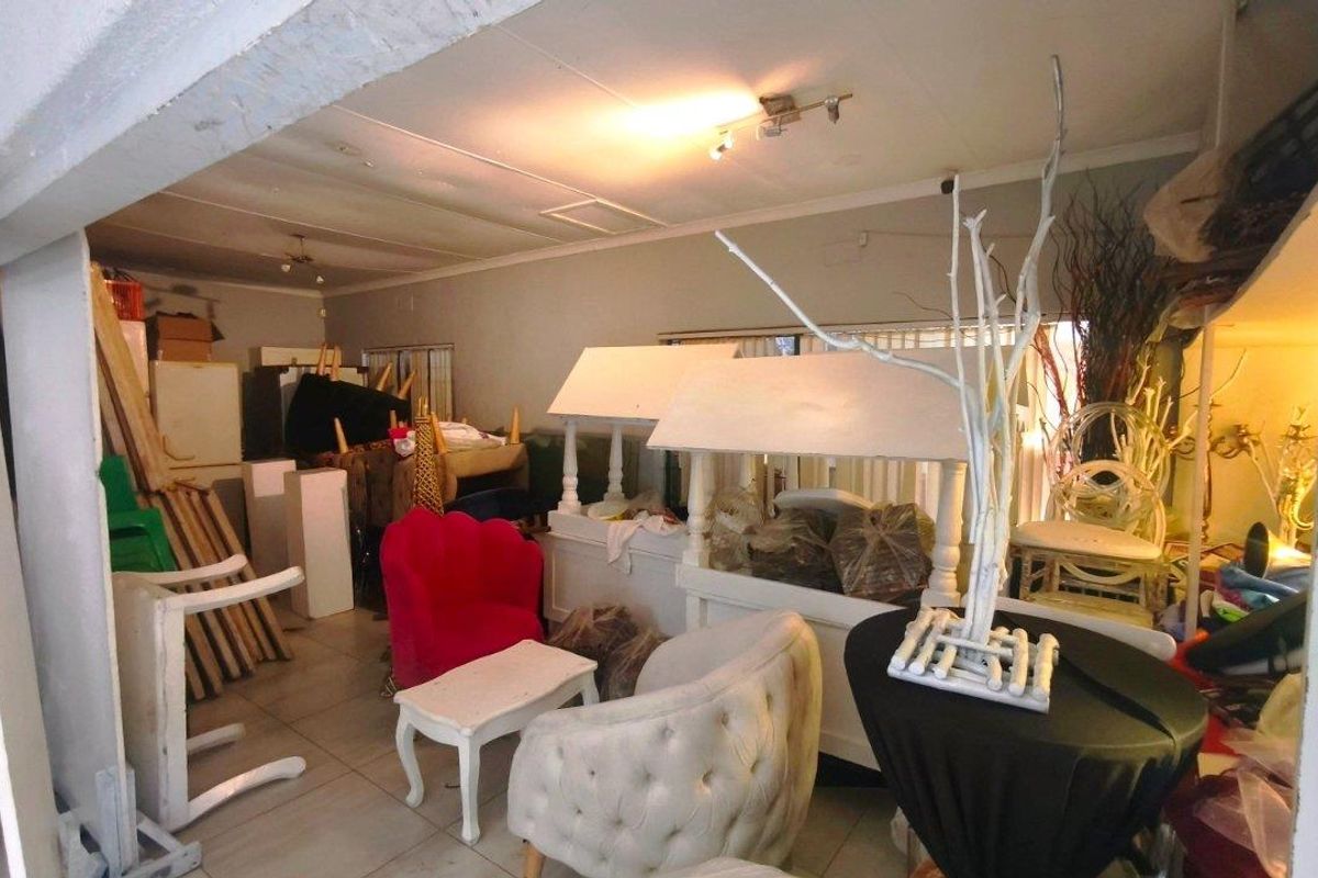 A spacious interior area featuring tiled flooring and basic lighting, currently utilized for storage with potential for renovation or repurposing.