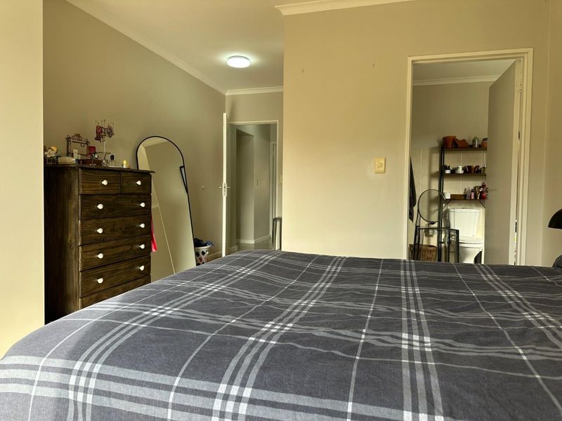 A bedroom featuring neutral wall tones, coving, and an en-suite bathroom access point, providing a functional and well-lit living space.