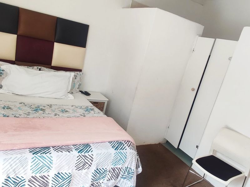 A bedroom featuring built-in cupboards and a neutral interior finish.