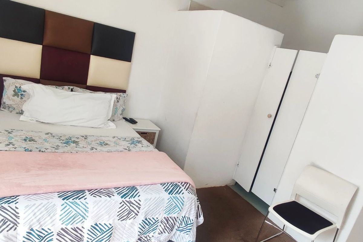 A bedroom featuring built-in cupboards and a neutral interior finish.