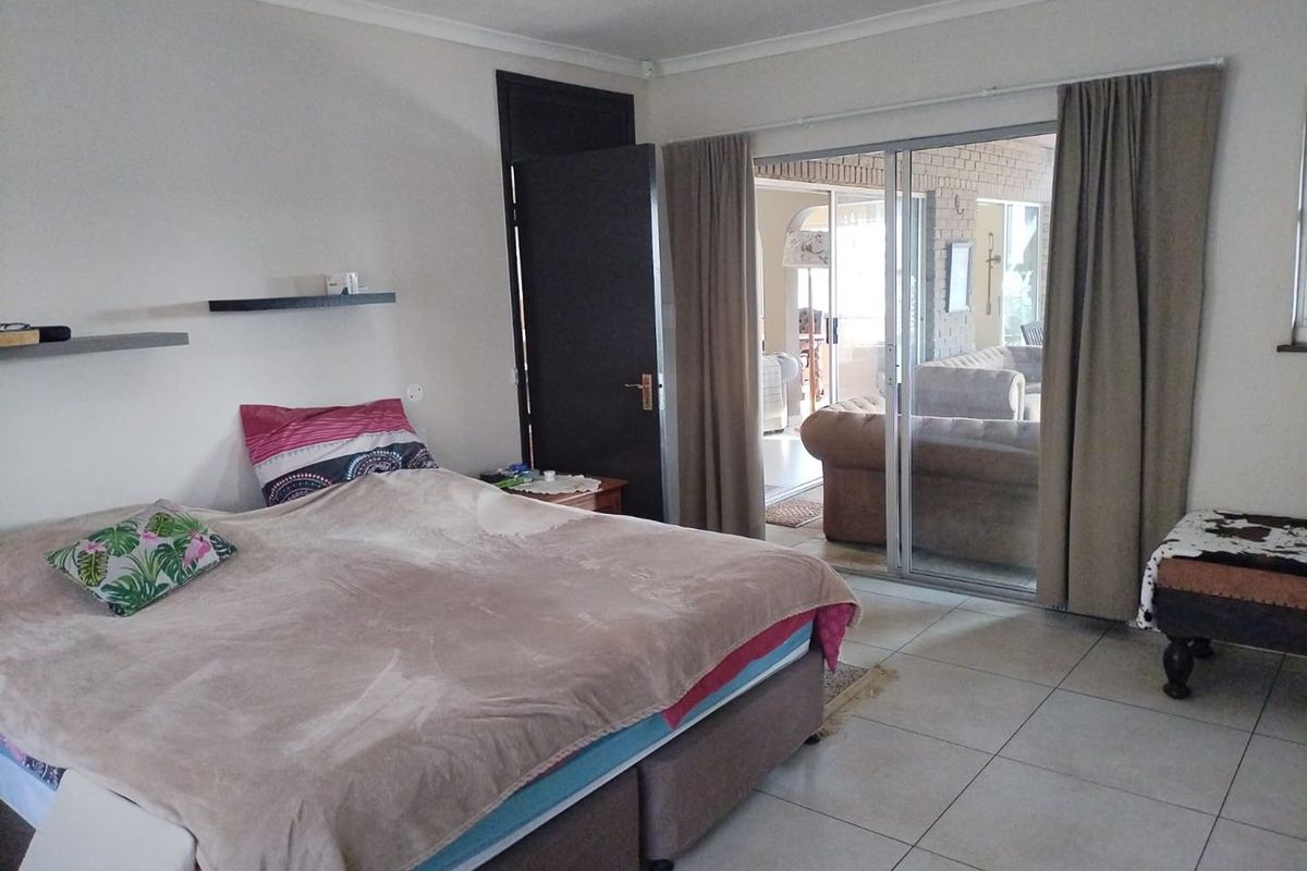 Spacious bedroom featuring tiled flooring and a sliding glass door providing direct access to an outdoor patio area.