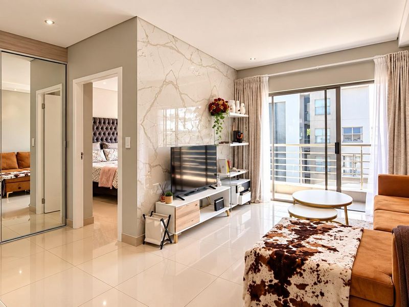 Modern living room featuring a marble-look feature wall, tiled flooring, recessed lighting, and direct access to a private balcony through sliding glass doors.