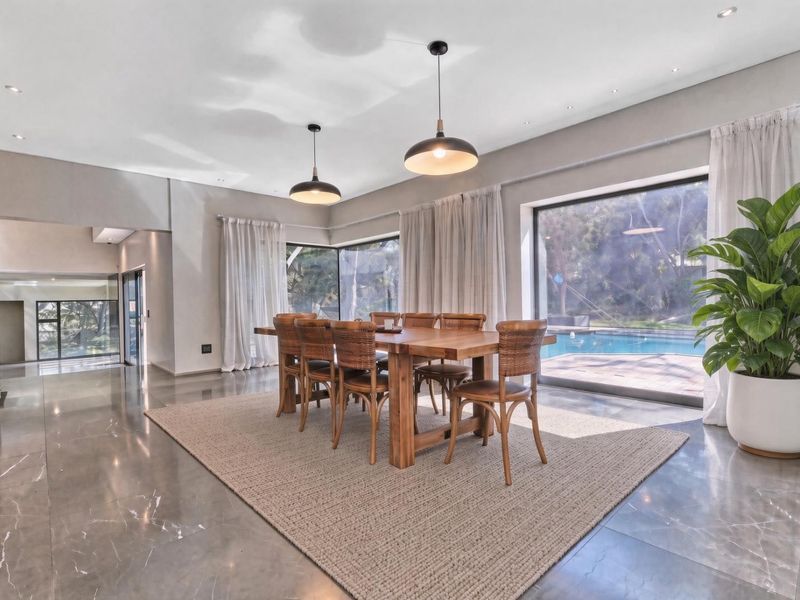 Spacious dining area featuring large format polished floor tiles, modern pendant lighting, and expansive sliding glass doors providing views of the pool area.
