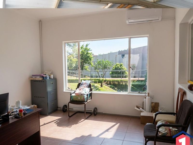 A functional office space featuring tiled flooring, a large window providing natural light, and a wall-mounted split-system air conditioner.