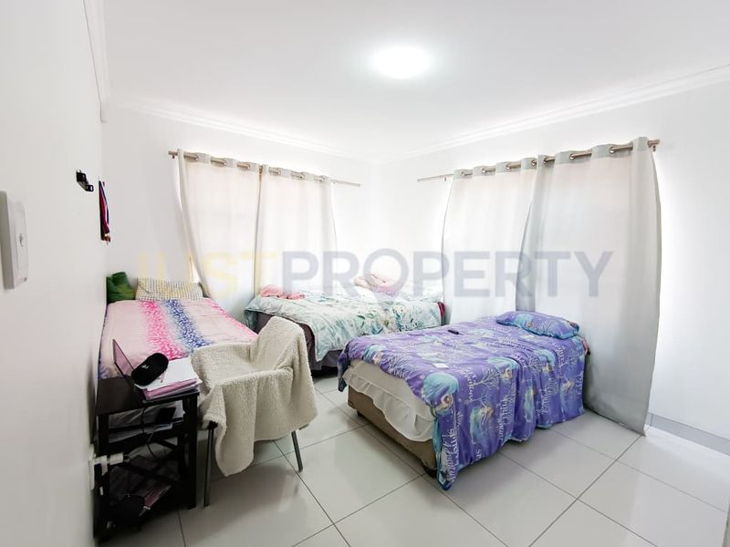 A functional bedroom featuring tiled flooring, coved ceilings, and dual window treatments, providing a neutral base for potential interior updates.