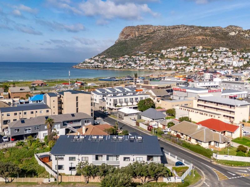 Aerial view of the townhouse complex and surrounding coastal neighborhood, showcasing proximity to the beach and local amenities.