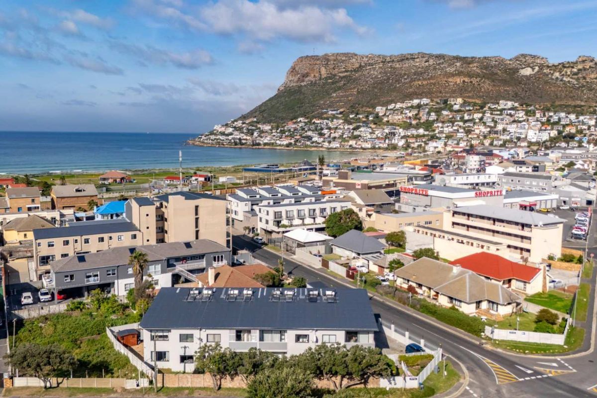 Aerial view of the townhouse complex and surrounding coastal neighborhood, showcasing proximity to the beach and local amenities.