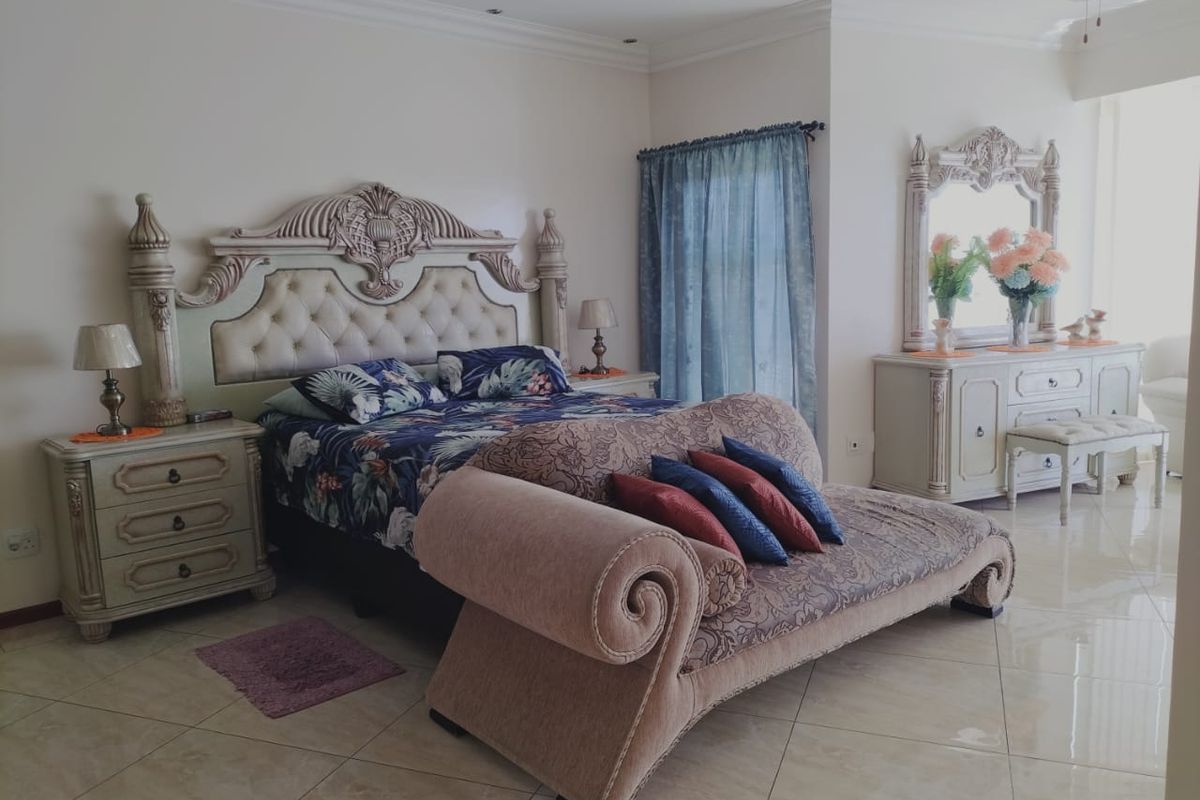 Spacious bedroom featuring tiled flooring, recessed ceiling lighting, and a large window with curtain treatments.