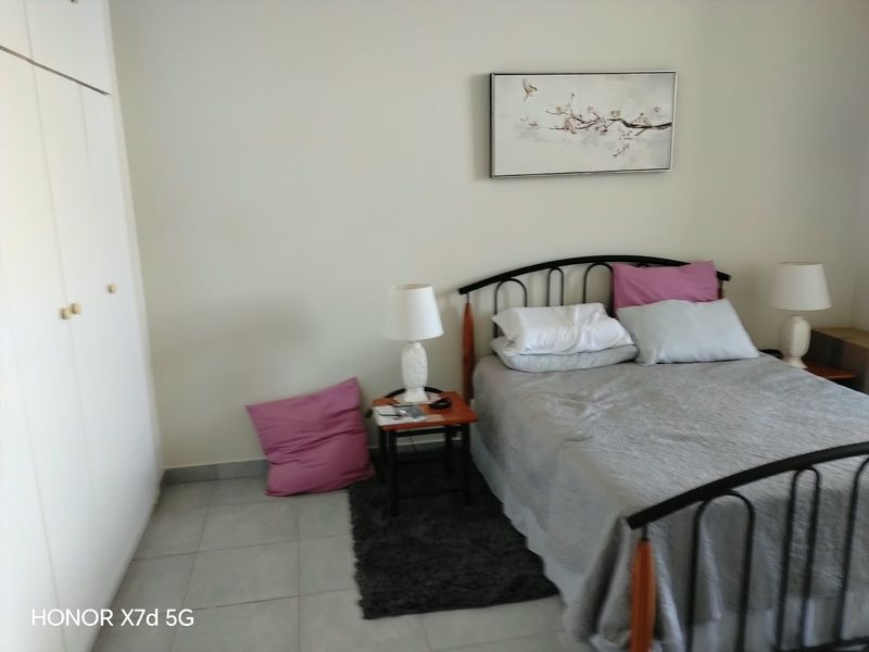 A functional bedroom featuring built-in wardrobes and tiled flooring, offering a clean and simple space ready for personalization.
