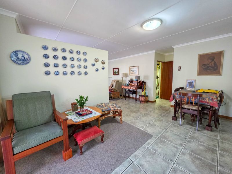 Spacious open-plan living and dining area featuring a combination of tiled and carpeted flooring with neutral wall finishes.