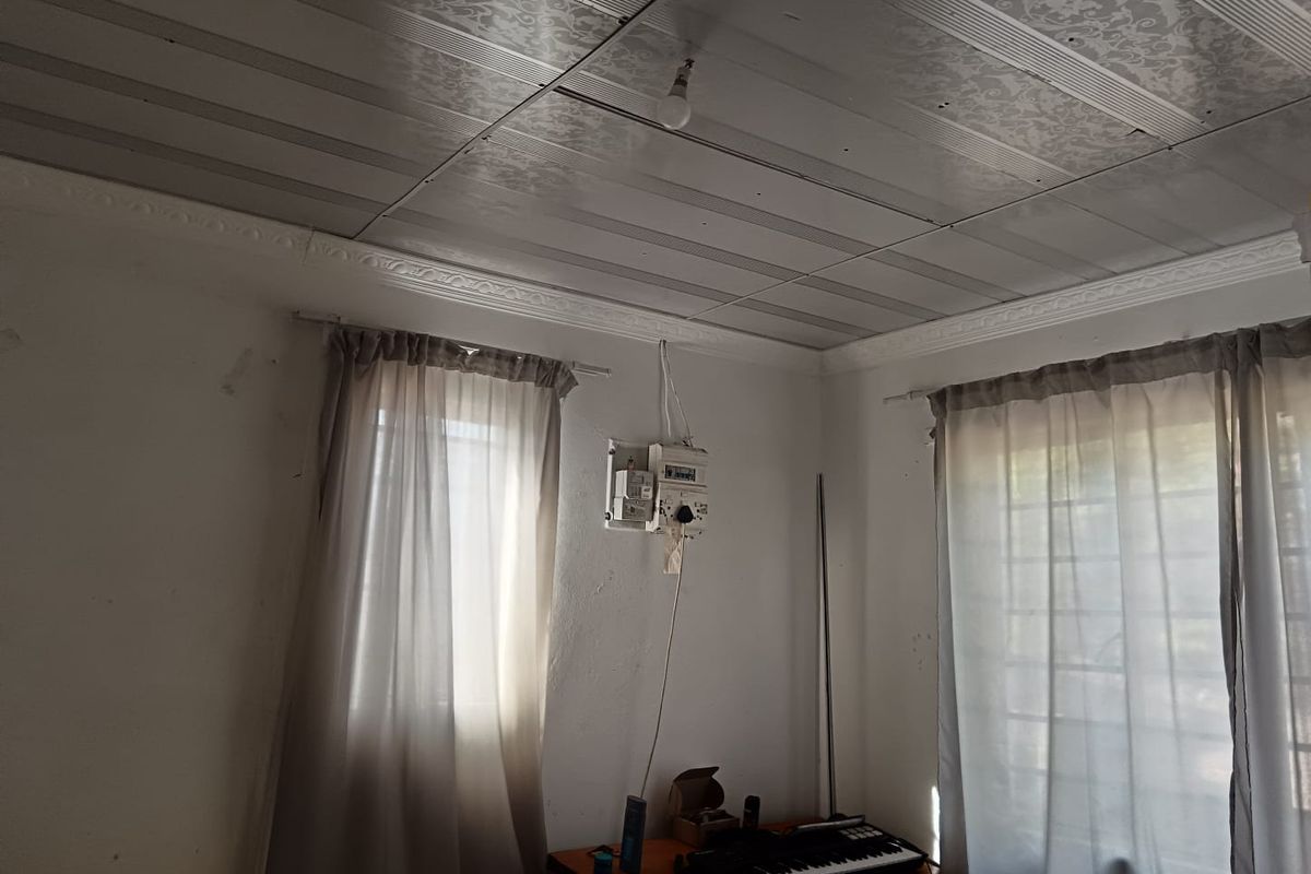 A bedroom featuring decorative ceiling panels, cornice detailing, and an exposed electrical distribution board on the wall.