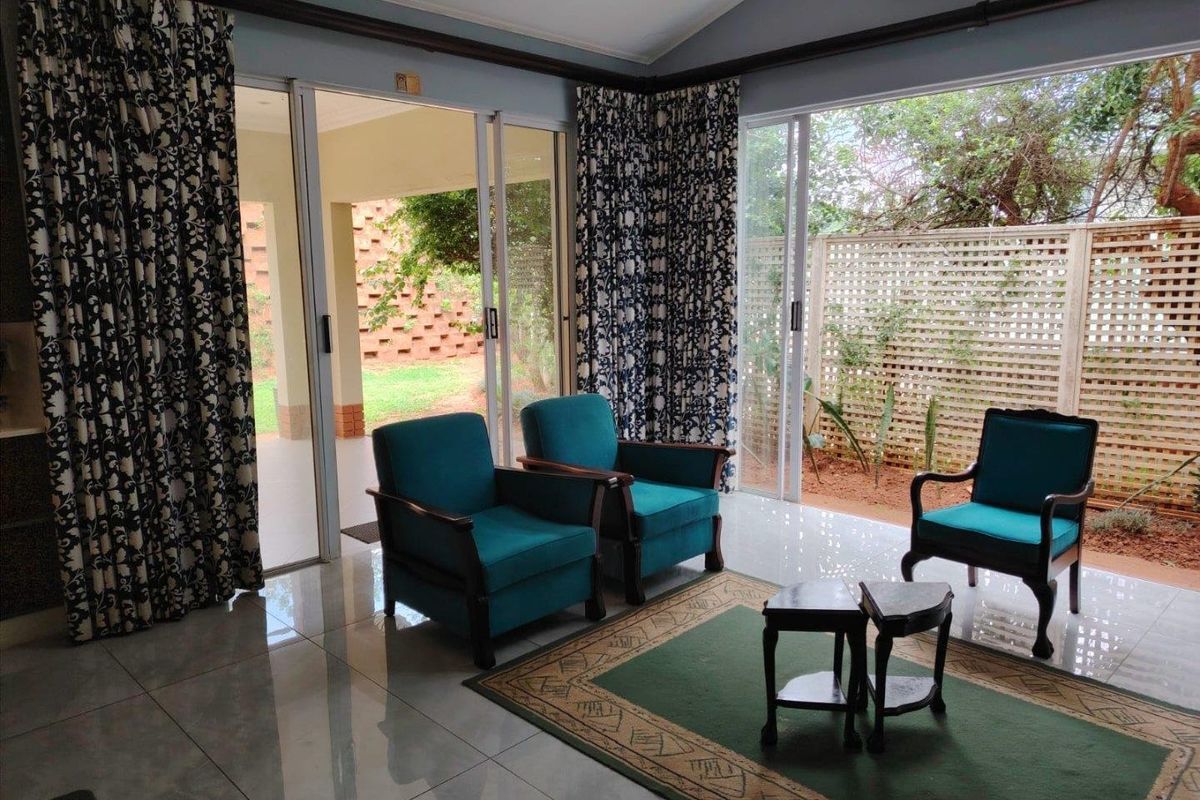 Bright living room featuring large sliding glass doors that provide seamless access to the outdoor patio and garden area.