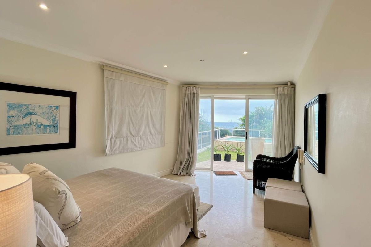 Spacious bedroom featuring tiled flooring, recessed lighting, and large sliding glass doors providing direct access to a private patio and pool area.
