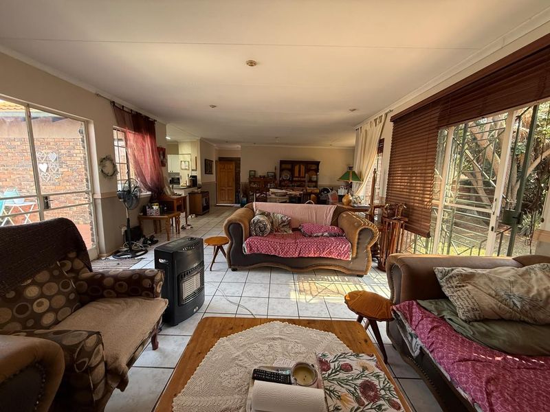 Spacious open-plan living area featuring tiled flooring, large sliding glass doors providing natural light, and direct access to the outdoor space.