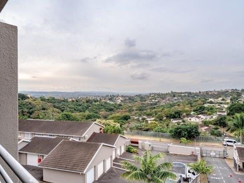 Elevated view overlooking the surrounding residential neighborhood and lush green landscape from a balcony.