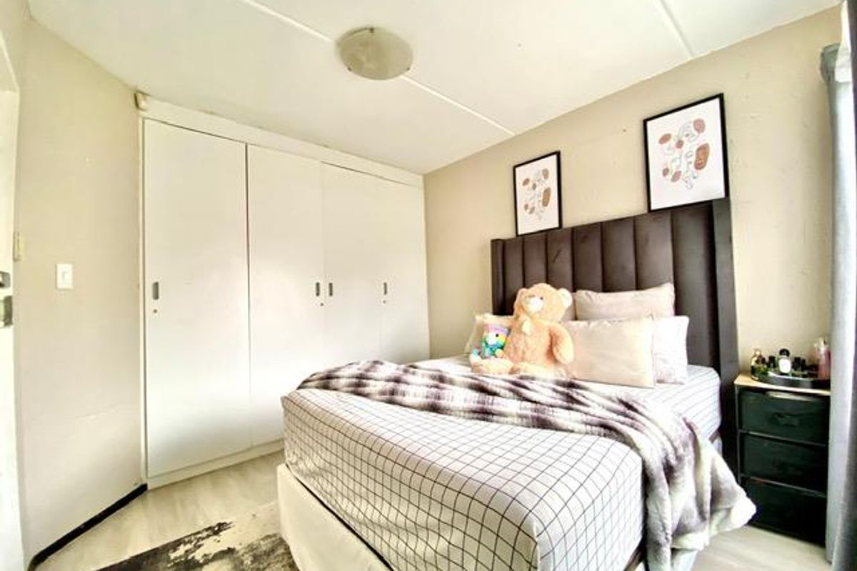 A bedroom featuring built-in floor-to-ceiling wardrobes and light-toned flooring, providing a functional and neutral space.